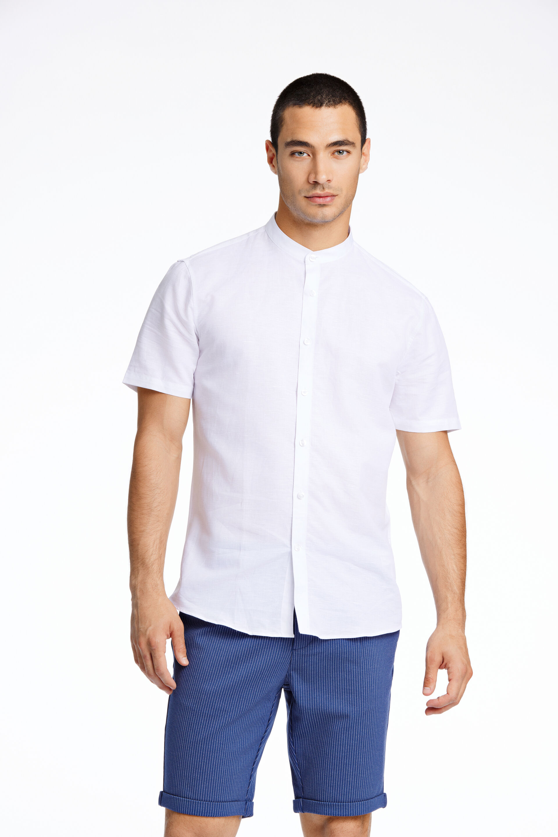 Model in wit Lindbergh-shirt met korte mouwen en blauwe Lindbergh-short
