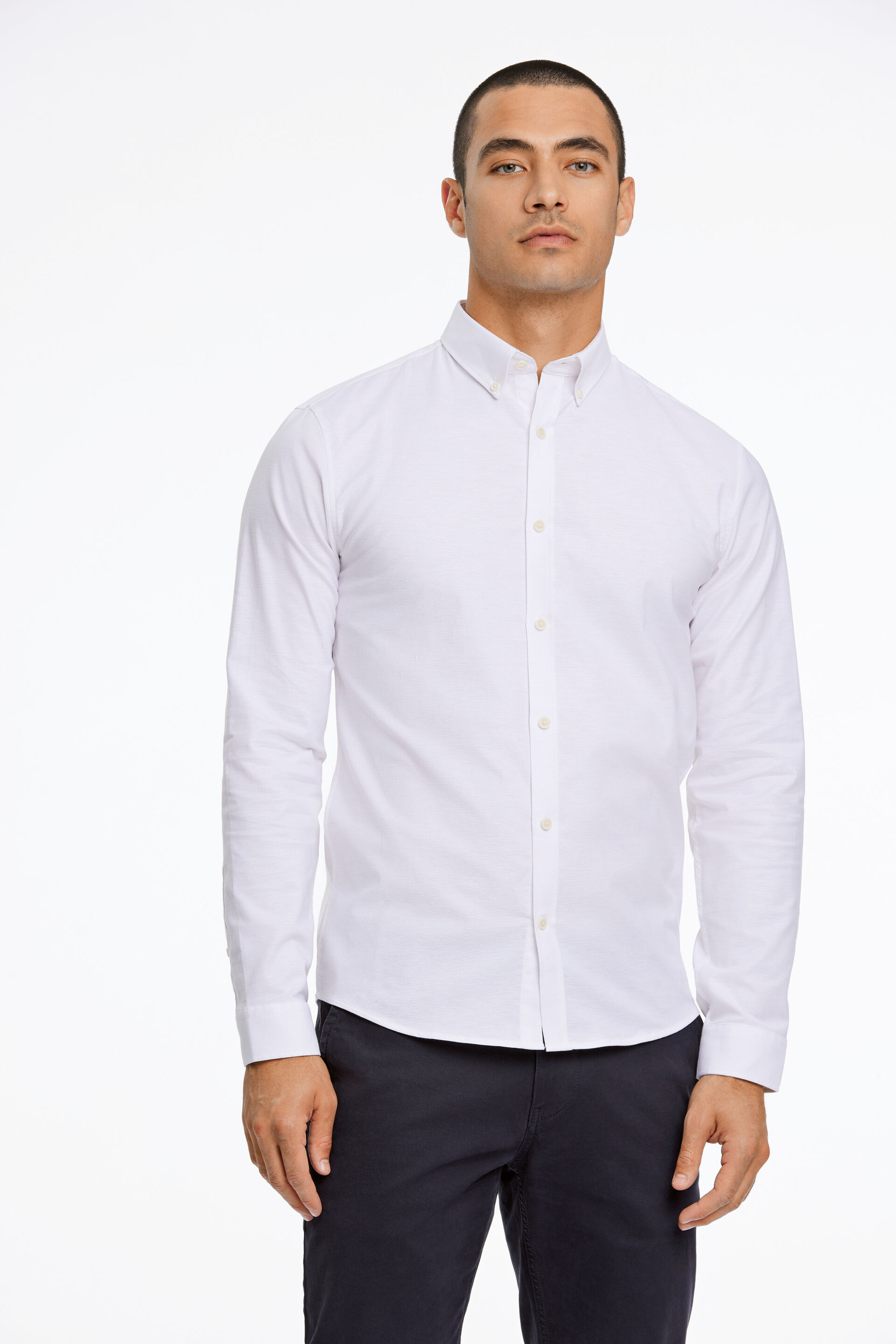 Model i hvid Lindbergh Oxfordskjorte og sorte habitbukser