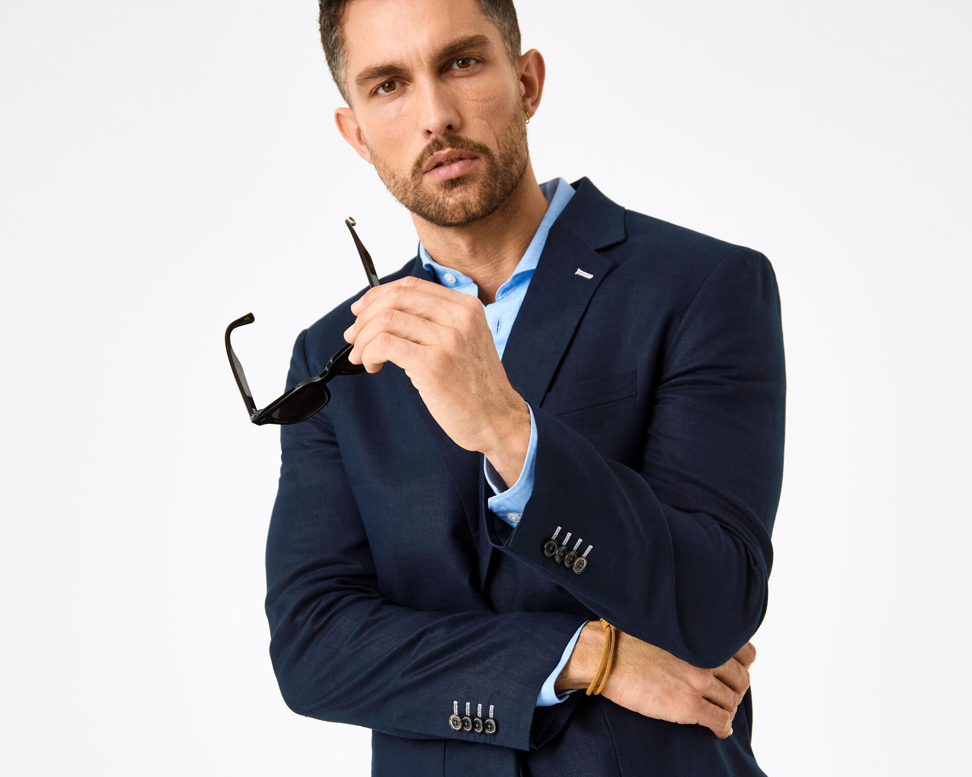 Man in navy blue linen suit with a light blue shirt on