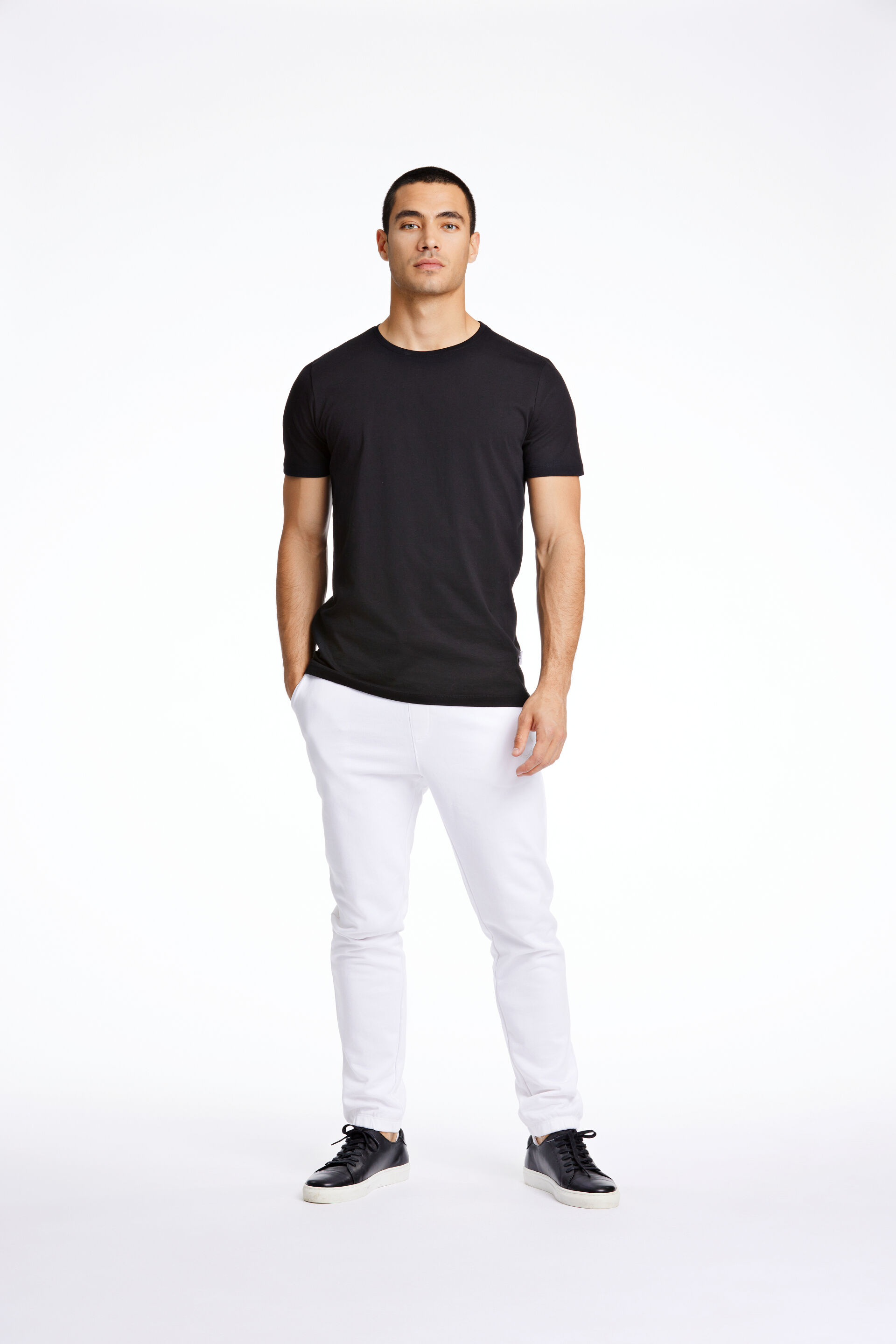 Model i sort Lindbergh T-shirt og hvide Lindbergh sweatpants