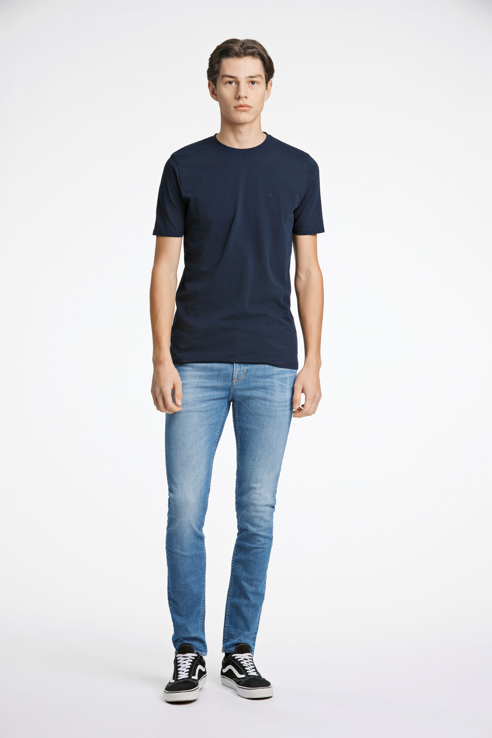 Model i mørkeblå JUNK de LUXE T-shirt og blå JUNK de LUXE jeans